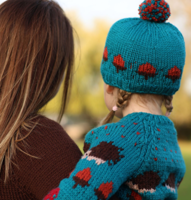 Child wearing knitted cardigan and hat