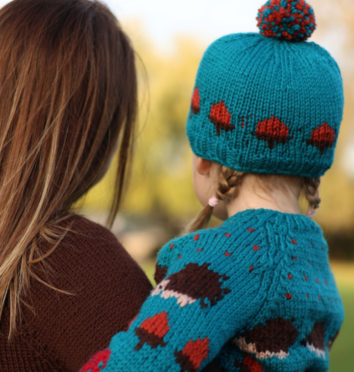 Child wearing knitted cardigan and hat