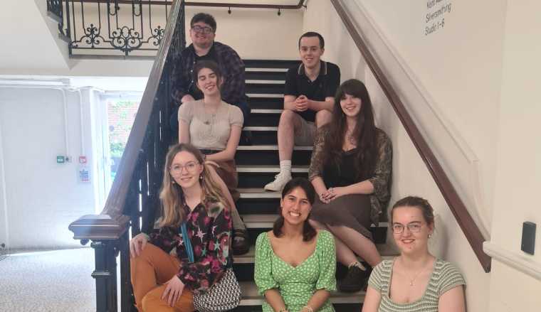 The Young producers seating on the steps of the Amelia building